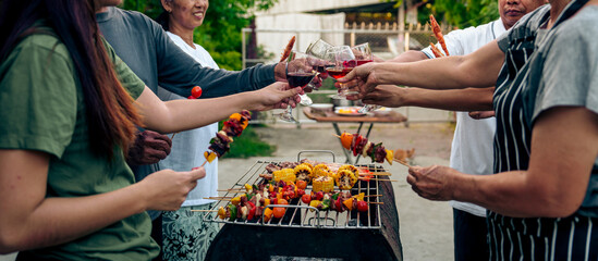 Home Garden BBQ Party, Wine Glasses Clink in Family Toast, enjoying harvest time together outside at front of house, grandfather and grandfather asian people, man and woman - obrazy, fototapety, plakaty