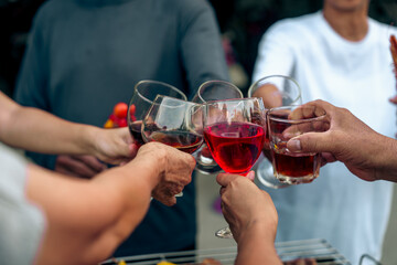 Home Garden BBQ Party, Wine Glasses Clink in Family Toast, enjoying harvest time together outside at front of house, grandfather and grandfather asian people, man and woman
