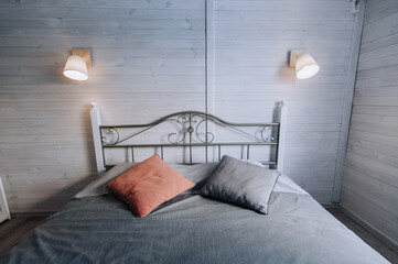 Interior in bedroom, room with bed, pillows, lamp, clean bedding. Photography, cozy atmosphere for relaxation.