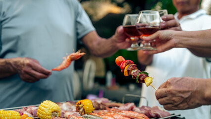 Home Garden BBQ Party, Wine Glasses Clink in Family Toast, enjoying harvest time together outside at front of house, grandfather and grandfather asian people, man and woman