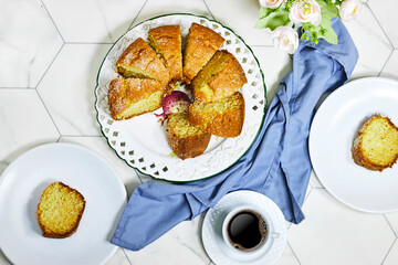 delicious coconut bundt cake with flowers vase with cup of coffee on hexagon background