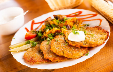 Potato pancakes with grilled beef dish on a white plate