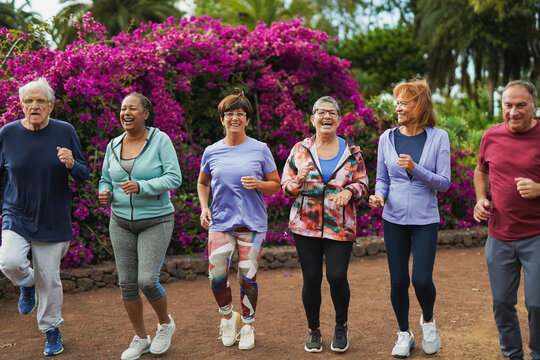 Group of senior people doing endurance sport routine outdoor with city park in background - Elderly friends and community concept