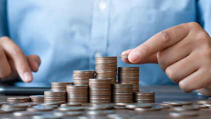 Saving money concept.Hand putting money coin stack.Financial concepts and financial investment business stock growth.