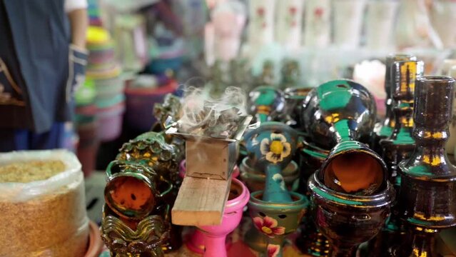An adult Hispanic woman selling copal goblets during day of the dead