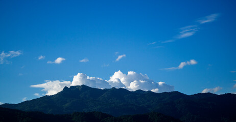 Green mountains, clear sky, and white clouds.