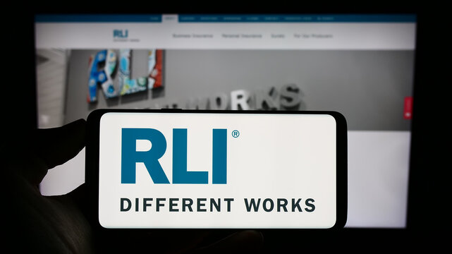 Stuttgart, Germany - 09-02-2023: Person holding cellphone with logo of US insurance company RLI Corp. on screen in front of business webpage. Focus on phone display.