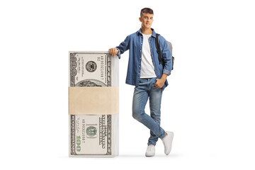 Male student leaning on a stack of us dollar banknotes