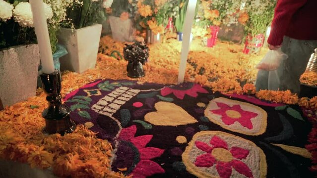 A skull made of flowers decorating a grave during day of the dead celebration
