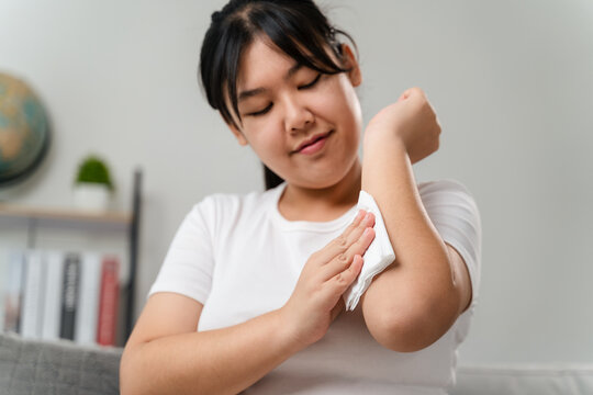 Woman wipes cleaning her arm with a tissue paper towel. Healthcare and medical concept.