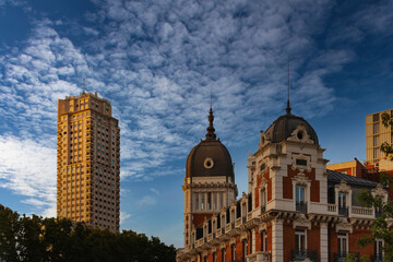 A stunning view of old buildings in the city of Madrid, Spain, bathed in the warm glow of the evening sun under a beautiful blue sky