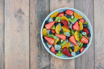 Fresh fruit salad bowl on wood grain table concept healthy food, to control weight, to lose weight