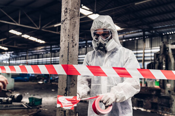 Scientist wear Chemical protection suit check danger chemical, working at dangerous zone in Red and White Lines of barrier tape. Red and white Hazardous restricted area factory safety worker industry