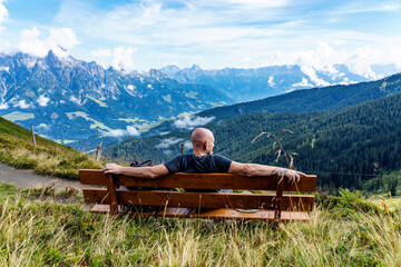 person sitting on a bench in the mountains