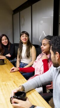 multiracial young group of employees or students in meeting room chatting laughing