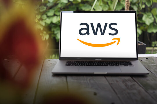 AWS logo (Amazon Web Services), a subsidiary of Amazon that provides on-demand cloud computing platforms and APIs, displayed on a MacBook Pro screen