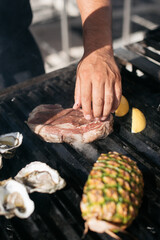 hand grilling steak on a grill outside