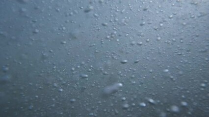 Underwater view of waves at the beach as the water rushes in and out.