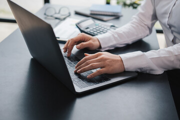 Portrait of Young Successful asian Businesswoman Sitting at Desk Working on Laptop Computer in City Office.