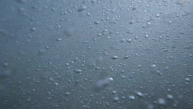 Underwater view of waves at the beach as the water rushes in and out.