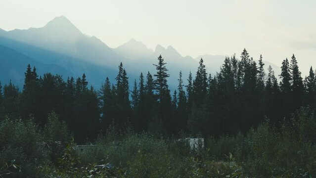 A shot of the landscape of Jasper National Park in Canada, in the early morning. In the shot is an elks and a RV, at a  public campsite in Canada