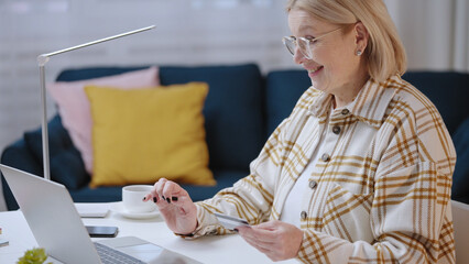 A woman in her 50s is paying for goods online with her credit card, taking advantage of modern technology