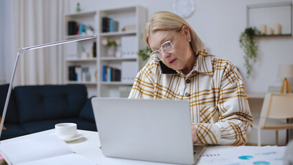 Busy woman talking on phone and working with business papers, financial analyst