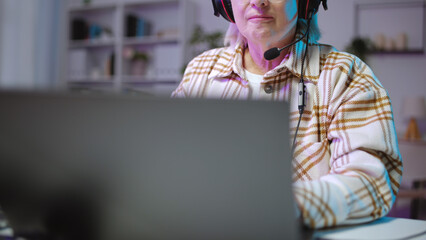 Close-up of a mature woman playing a video game on her laptop in an online tournament