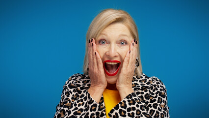An excited woman in her 50s is making a shocked face, in response to a huge discount or sale