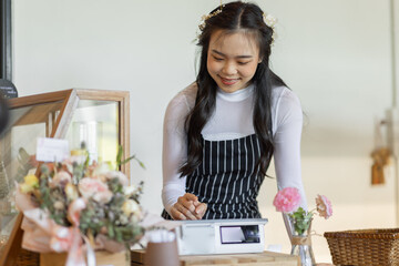 Stop by for homemade delicious bread! Portrait of asian young entrepreneur woman embracing work in her the bakery small business waiter standing in front of bakery shop.