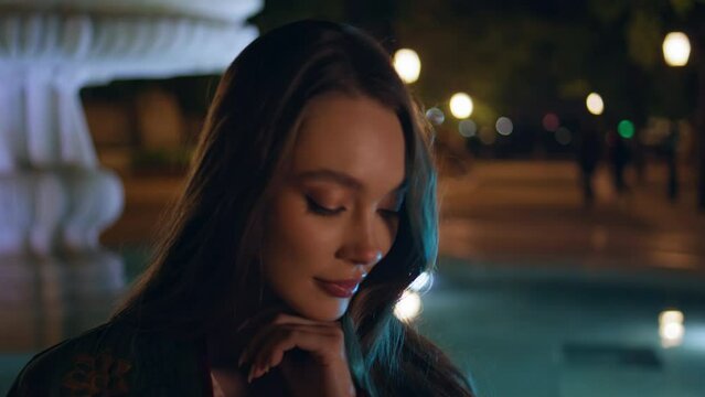Gorgeous woman posing fountain night city close up. Model standing dark square