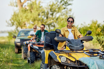 Portrait of a happy woman enjoying a quad bike ride with her friends. © bnenin