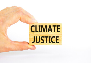 Climate justice symbol. Concept words Climate justice on beautiful wooden blocks. Beautiful white table white background. Businessman hand. Business environment climate justice concept. Copy space.