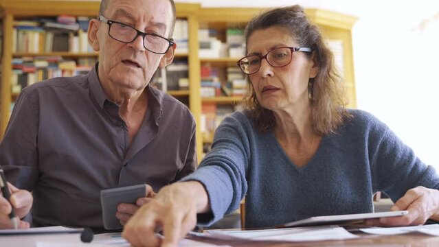 Senior couple with tablet managing bills and paperwork. Domestic life budget