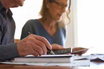 Senior couple with tablet and calculator smile while managing bills and taxes with copy space. Domestic life budget