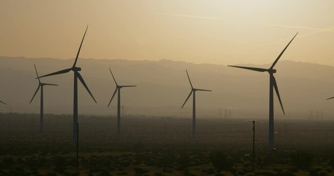 Wind turbines, windmills spinning in a field near Palm Springs San Gorgonio Pass. Mountains in background