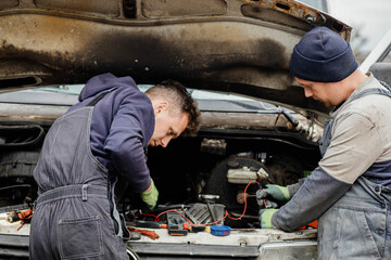 two master auto mechanics diagnosing a van with the hood raised