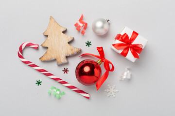 Miniature christmas tree with gift box and decor on color background