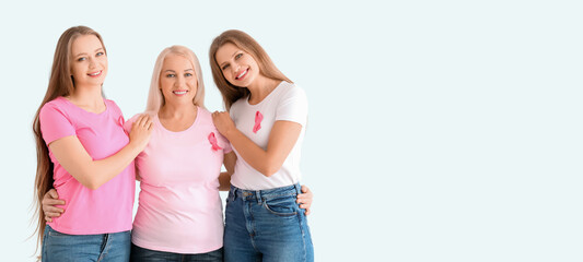 Beautiful women with pink ribbons on light background with space for text. Breast cancer awareness