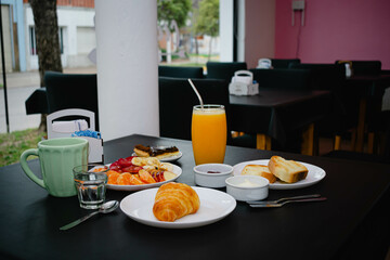 Restaurant breakfast, coffee, croissant, orange juice, toast, jam, fruits and chocolate cake