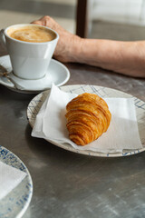 Closeup, a crispy puff pastry bun served on a plate, on the cafeteria table