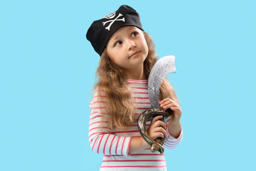 Obraz premium Cute little girl dressed as pirate with sword on blue background