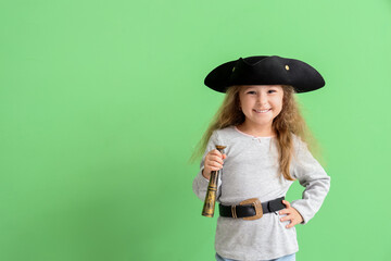 Cute little girl dressed as pirate with spyglass on green background - obrazy, fototapety, plakaty