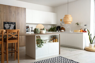 Interior of light kitchen with modern appliances on wooden table