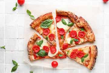 Slices of tasty pizza Margarita and fresh tomatoes on beige tile background