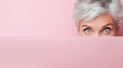 text space for advertising with funny part as portrait of a aged female model with gray hair peeking over a colored panal