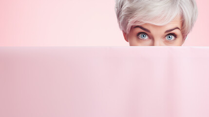 text space for advertising with funny part as portrait of a aged female model with gray hair peeking over a colored panal