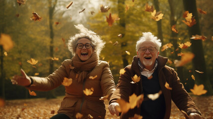 Active seniors having fun and playing with the leaves in autumn forest. Healthy and active elderly couple. Happy couple on retirement, healthy and active lifestyle. - Powered by Adobe