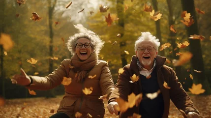 Keuken spatwand met foto Active seniors having fun and playing with the leaves in autumn forest. Healthy and active elderly couple. Happy couple on retirement, healthy and active lifestyle. © Dirk