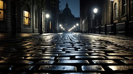 Gordijnen Rain-soaked black and white cobblestones reflecting the glow of lampposts © nomi_creative